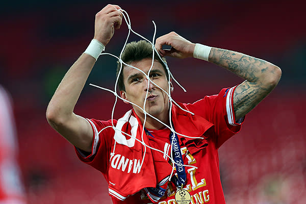 Mario Mandzukic of Bayern Munchen celebrates with a piece of goal netting after winning the UEFA Champions League final.