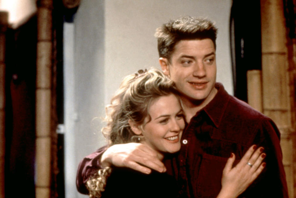Alicia silverstone and Brendan Fraser share a hug as Eve and Adam