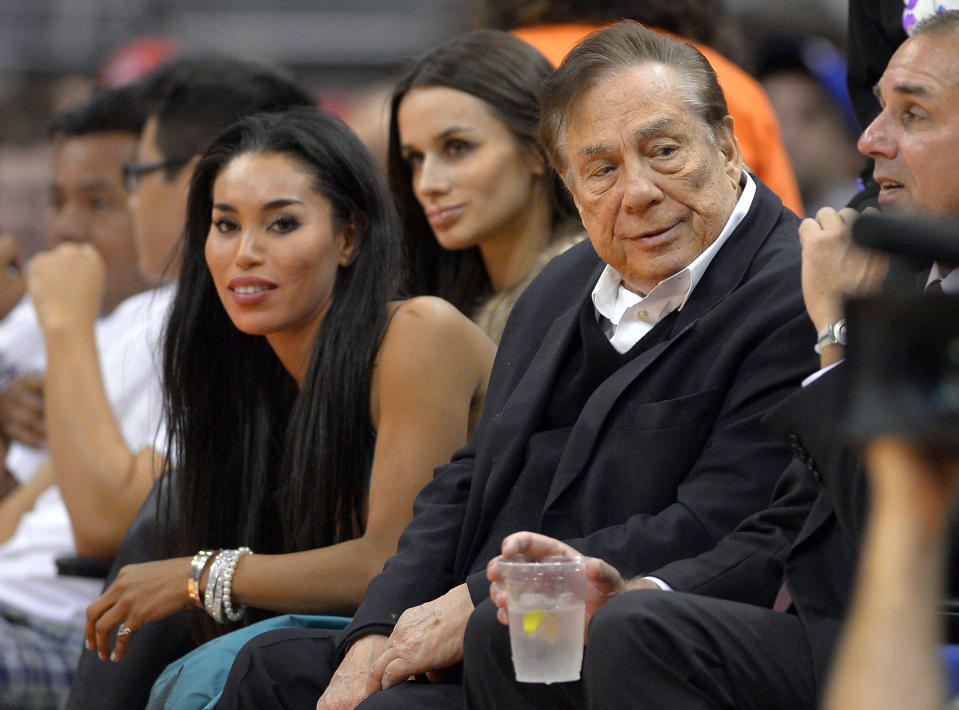 El dueño de los Clippers, Donald Sterling, segundo desde la derecha, acude a un partido de los Clippers contra los Kings el 25 de octubre de 2013. Sterling fue suspendido de por vida de la NBA y multado 2,5 millones de dólares por comentarios racistas. (AP Photo/Mark J. Terrill)