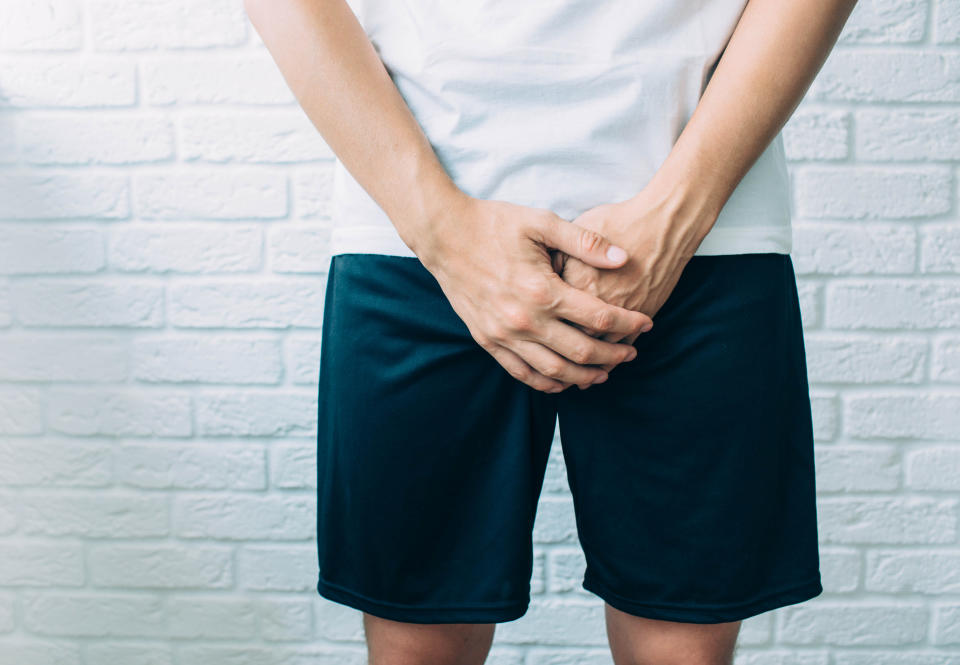 man wearing shorts holding genitals. Men's health, venereologist, sexual disease