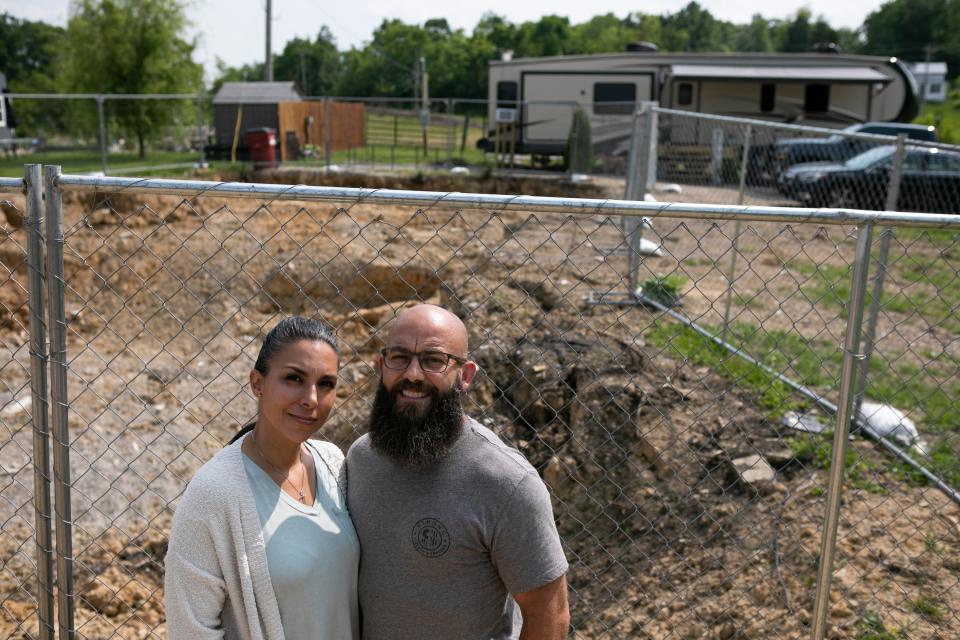 Vicky and Chad Burnett stand in front of the hole where their house use to be on May 23, 2023, in Huntington Township, Ohio. The Burnett's home burned down on March 5, 2023. Impressed with the response from the local fire departments, Chad is thinking of becoming a local firefighter. His application to the Huntington Township Fire Department has been approved.