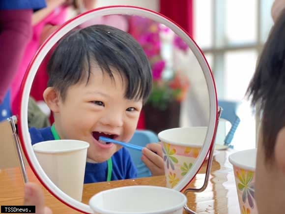 唐寶寶翔翔參加潔牙比賽開心按照護理師教導方式正確刷牙。（圖：新北社會局提供）