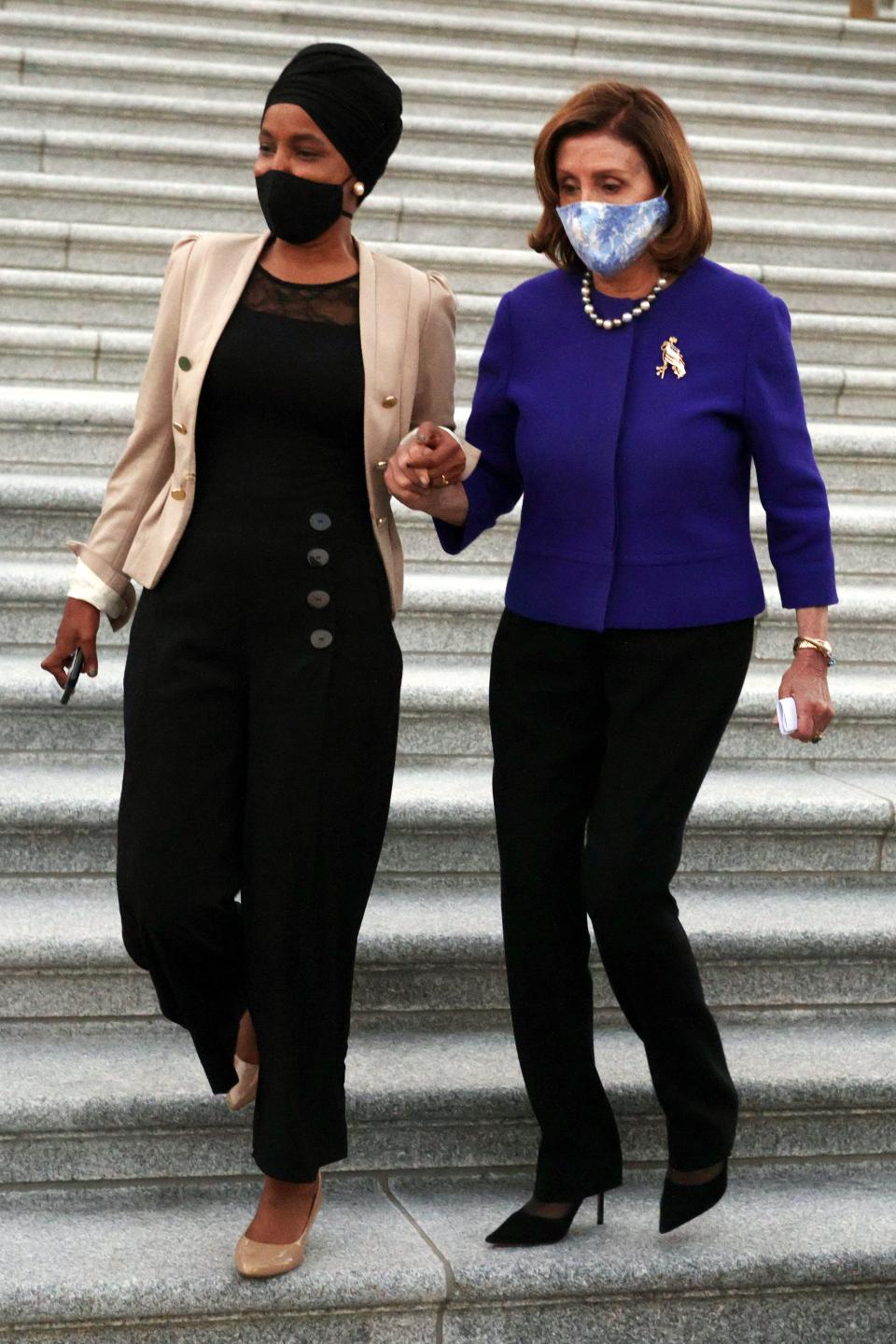 House Speaker of the HNancy Pelosi, D-Calif., (right)  and Rep. Ilhan Omar, D-Minn., (left) hold hands as they arrive at a group photo to mark the National Recovery Month outside the U.S. Capitol on Sept. 27, 2021 in Washington, D.C.