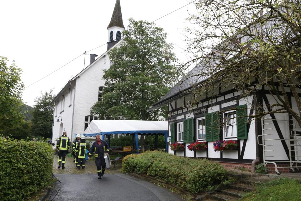 In this Sunday, Sept. 8, 2019 photo fire fighters are seen after an explosion at a village festival in Freudenberg, Germany. Authorities say 14 people have been injured, five of them with life-threatening burns, during an explosion at a village festival in western Germany. Police told German news agency dpa that it appears likely that oil inside a big frying pan caused the explosion at the local 'Backesfest' (bakery festival) that was attended by about 100 people. (Berthold Stamm/dpa via AP)