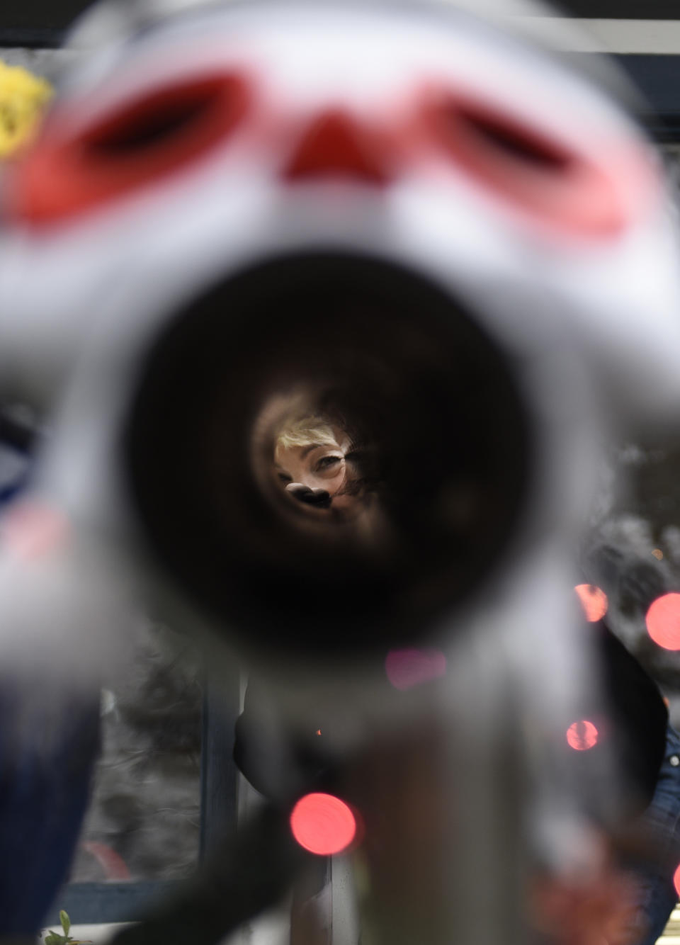 Carol McCarthy looks down the candy chute that she will use to give out treats to socially-distant trick-or-treaters on Halloween, Monday, Oct. 26, 2020, in Palmyra, N.J. (AP Photo/Michael Perez)