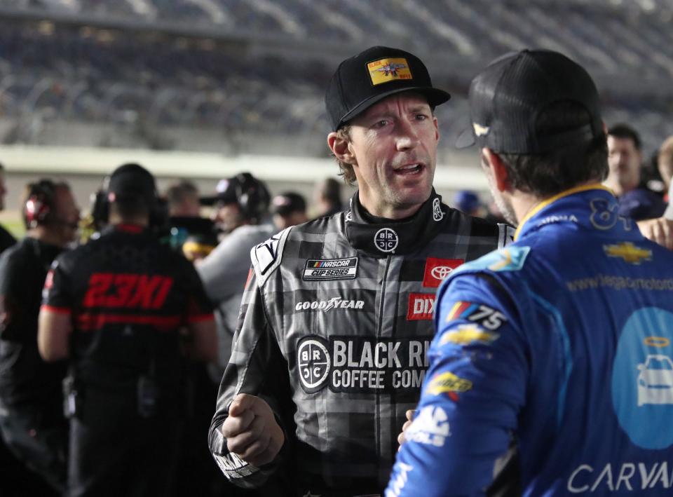 Travis Pastrana talks with Jimmie Johnson while waiting for the start of Daytona 500 qualifying, Wednesday, Feb. 15, 2023.