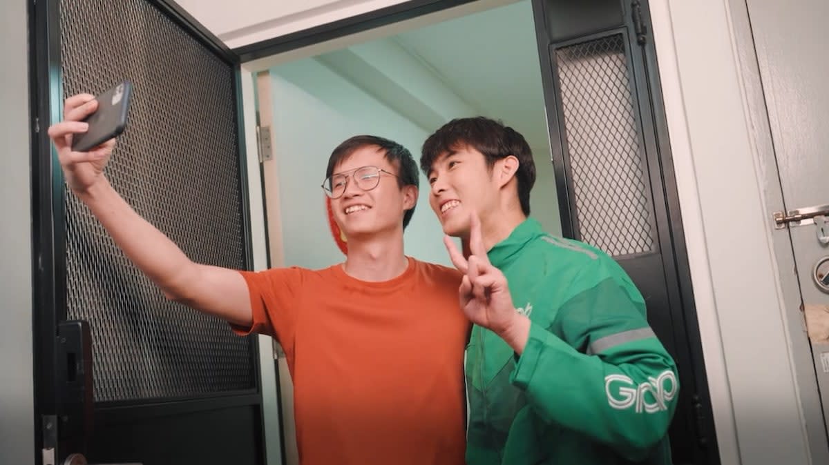 Singapore shuttler Loh Kean Yew (right) poses for a photo with a Grab app user during his one-day stint as Grab delivery-partner. (PHOTO: Grab Singapore)