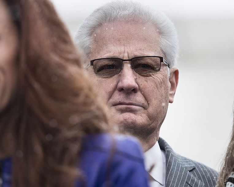 David Green, founder and CEO of Hobby Lobby, listens as others speak to the press outside the Supreme Court March 25, 2014 in Washington, DC.