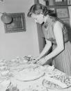 <p>The <em>Casablanca </em>star sets the table before entertaining family and friends for the first birthday of her twin daughters in 1953. </p>