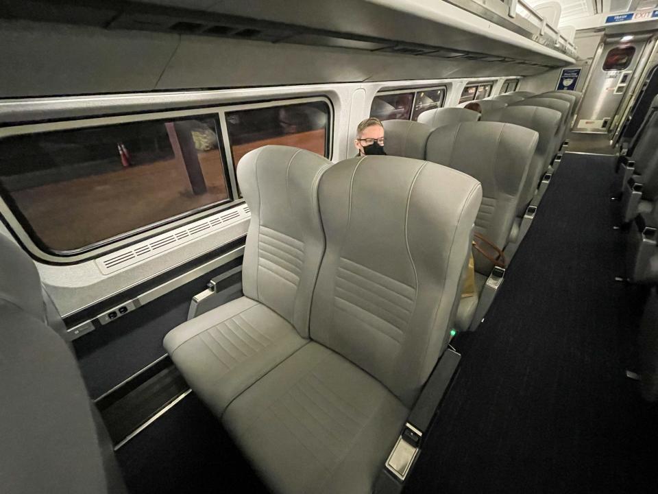 Rows of passenger seats with one passenger.