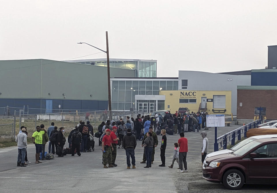 People without vehicles lineup to register for a flight to Calgary, Alberta in Yellowknife on Thursday, Aug. 17, 2023. Prime Minister Justin Trudeau is expected to convene an urgent meeting with ministers and senior officials today as residents of the capital of Northwest Territories are ordered to evacuate the area because of an encroaching wildfire. (Bill Braden /The Canadian Press via AP)