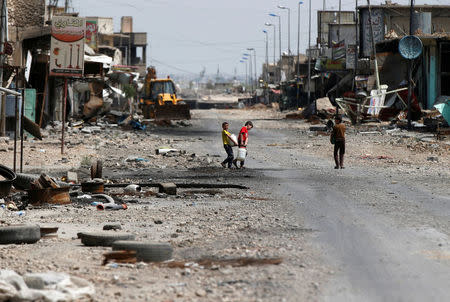 Iraqi children carry water containers after the battle between the Iraqi Counter Terrorism Service and Islamic State militants in western Mosul, Iraq, April 22, 2017. REUTERS/Muhammad Hamed