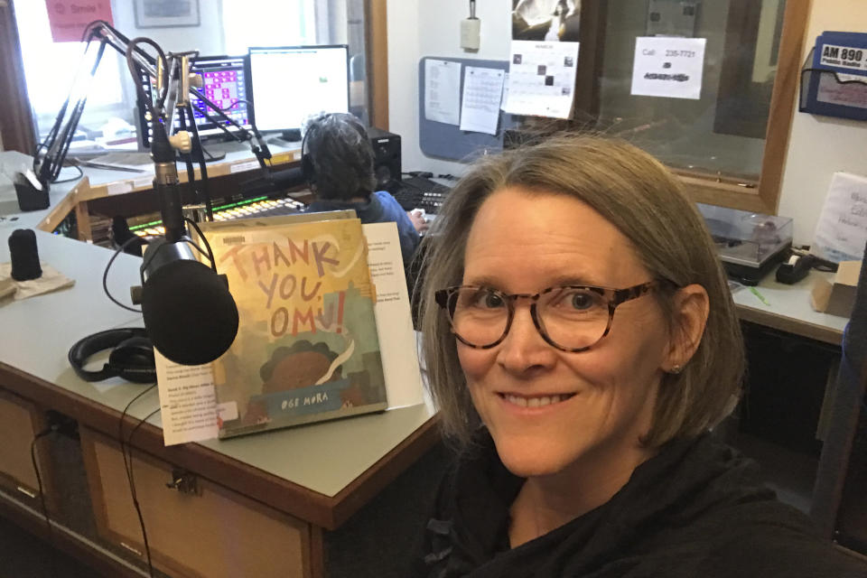 In this April 2, 2020, photo provided by librarian Claudia Haines, she poses for the selfie while preparing to read stories on the air at local radio station KBBI in Homer, Alaska. The library teamed up with the station to continue its popular story hour for preschoolers after it closed to the public amid coronavirus concerns. It's among ways the nation's libraries are dealing with closures amid coronavirus concerns. (Claudia Haines via AP)