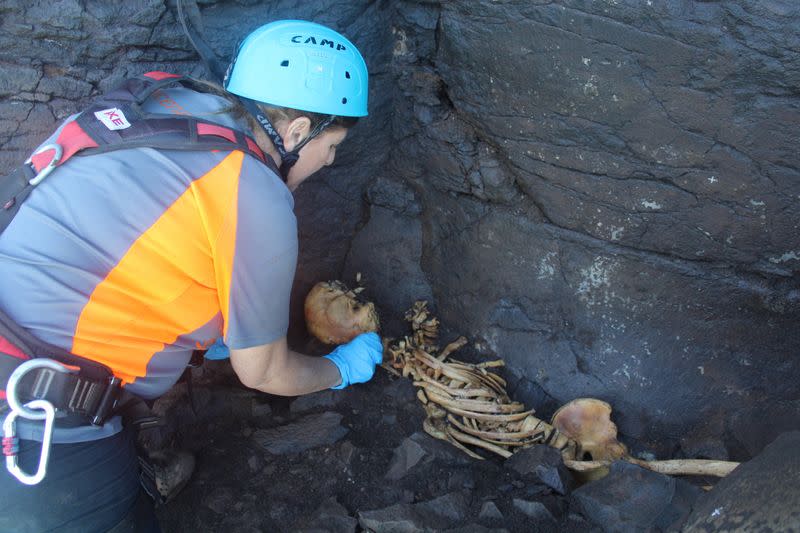 Archaeologist Veronica Alberto from Tibicena, an archaeology company, works on the extraction of human remains