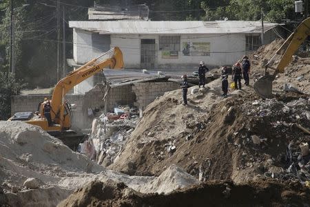 Rescue team members look for bodies at an area aftected by a mudslide, in Santa Catarina Pinula, on the outskirts of Guatemala City, October 7, 2015. REUTERS/Josue Decavele