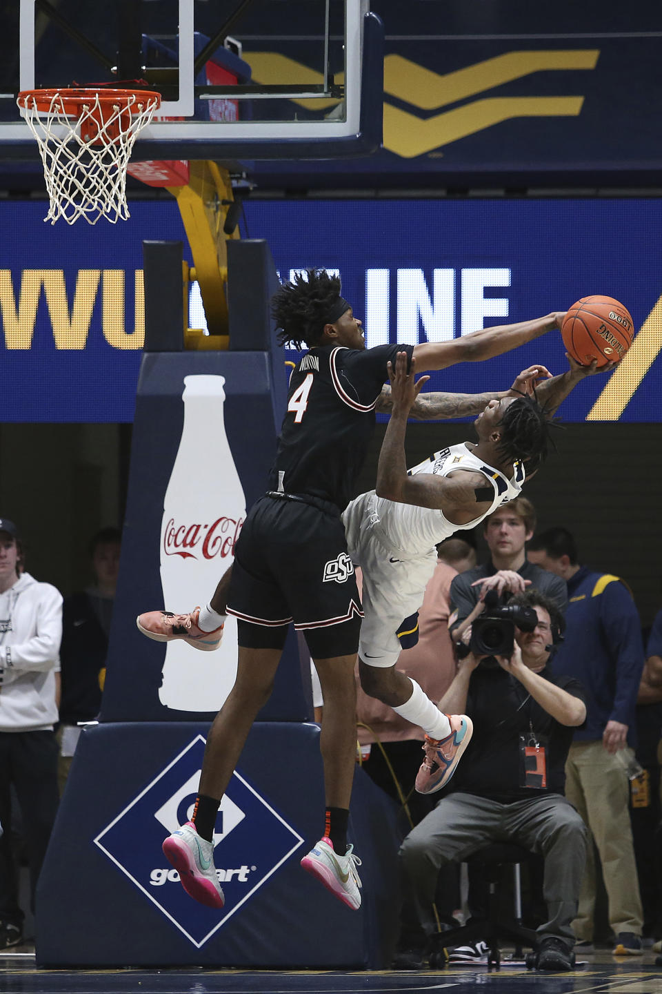 West Virginia guard Kedrian Johnson, right, is defended by Oklahoma State guard Woody Newton (4) during the first half of an NCAA college basketball game on Monday, Feb. 20, 2023, in Morgantown, W.Va. (AP Photo/Kathleen Batten)