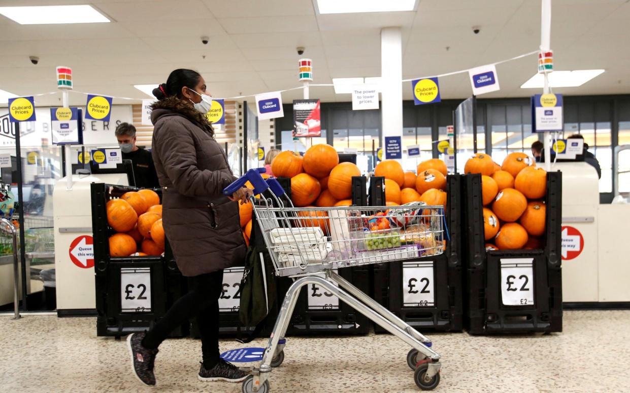  A woman wearing a face mask pushes a shopping cart at a Tesco supermarket in Hatfield, Britain October 6, 202 - PETER CZIBORRA/Reuters