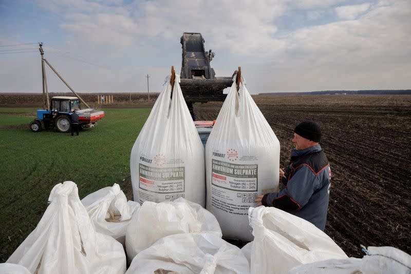 FILE PHOTO: A local farm worker unloads Ukrainian-made fertiliser from a truck to use on a wheat field near the village of Yakovlivka after it was hit by an aerial bombardment outside Kharkiv.