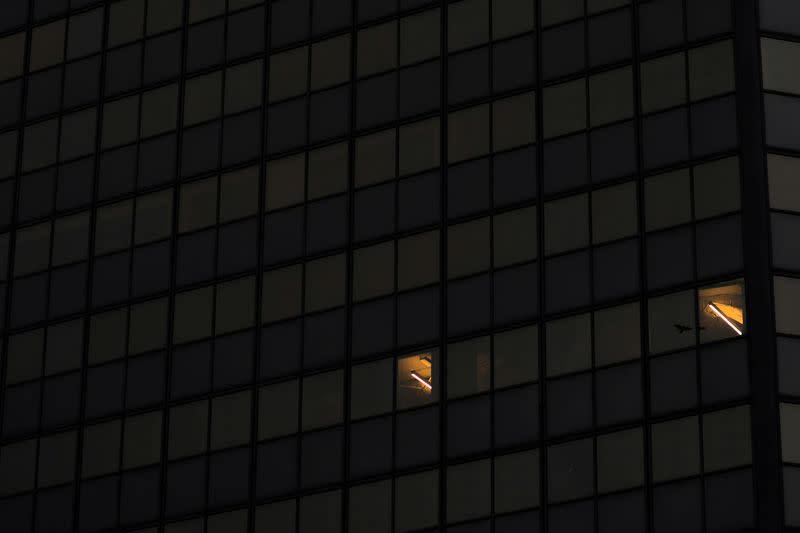 FILE PHOTO: Office lights are illuminated in a high rise building at dusk