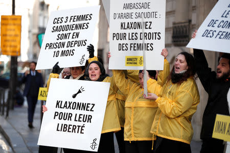 Demonstrators from Amnesty International hold placards outside the Saudi Arabian Embassy to protest on International Women's day to urge Saudi authorities to release jailed women's rights activists Loujain al-Hathloul, Eman al-Nafjan and Aziza al-Yousef in Paris, France, March 8, 2019. The placard reads: "Honk for women's rights". REUTERS/Benoit Tessier