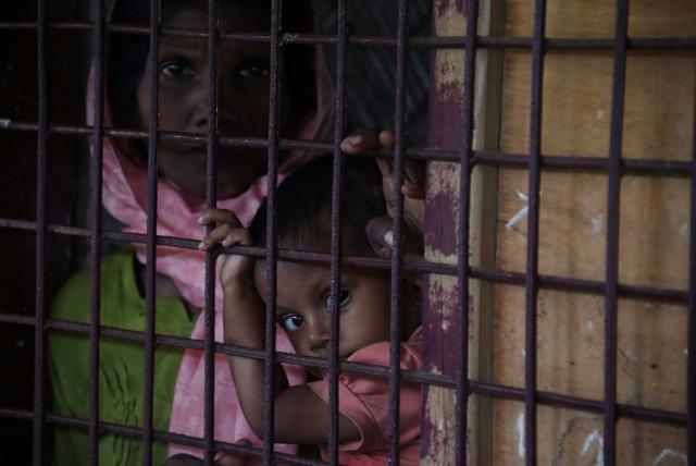 A Rohingya Muslim refugee and child look on as they sit in a school housing new refugees from Myanmar in Kutupalong refugee camp in the Bangaldeshi district of Ukhia on September 23, 2017