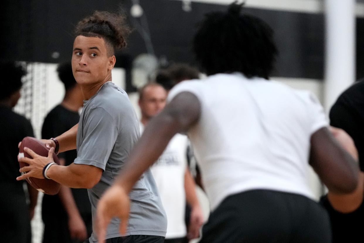 Lakota East quarterback Jamison Kitna throws after taking a snap during practice inside the school’s gymnasium, Monday, Aug. 7, 2023, at Lakota East High School in Liberty Township, Ohio.