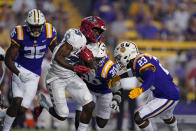 New Mexico running back Nathaniel Jones (25) carries against LSU linebacker Micah Baskerville (23) and linebacker Greg Penn III (30) in the second half of an NCAA college football game in Baton Rouge, La., Saturday, Sept. 24, 2022. LSU won 38-0. (AP Photo/Gerald Herbert)