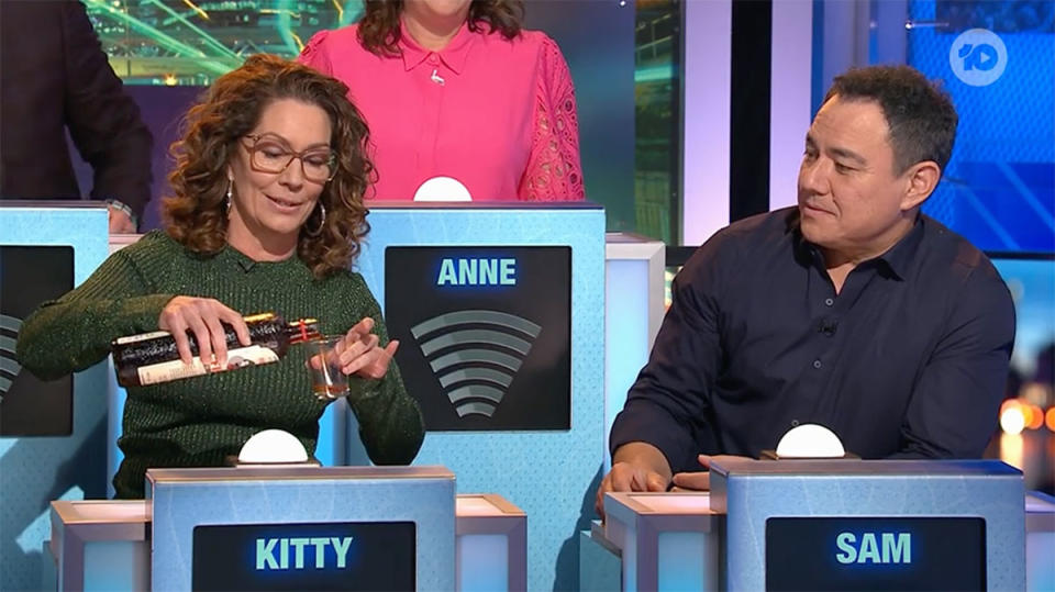 Kitty Flanagan pouring a shot of Fisk Liquor for Sam Pang on Have You Been Paying Attention