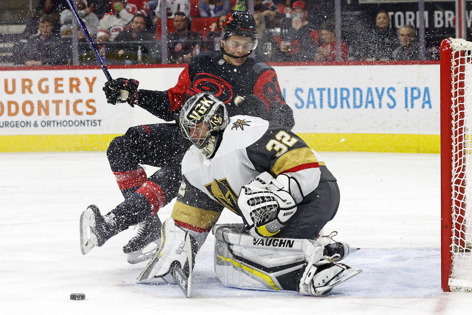 Carolina Hurricanes' Jesperi Kotkaniemi (82) collides with Vegas Golden Knights goaltender Jonathan Quick (32) during the second period of an NHL hockey game in Raleigh, N.C., Saturday, March 11, 2023. (AP Photo/Karl B DeBlaker)