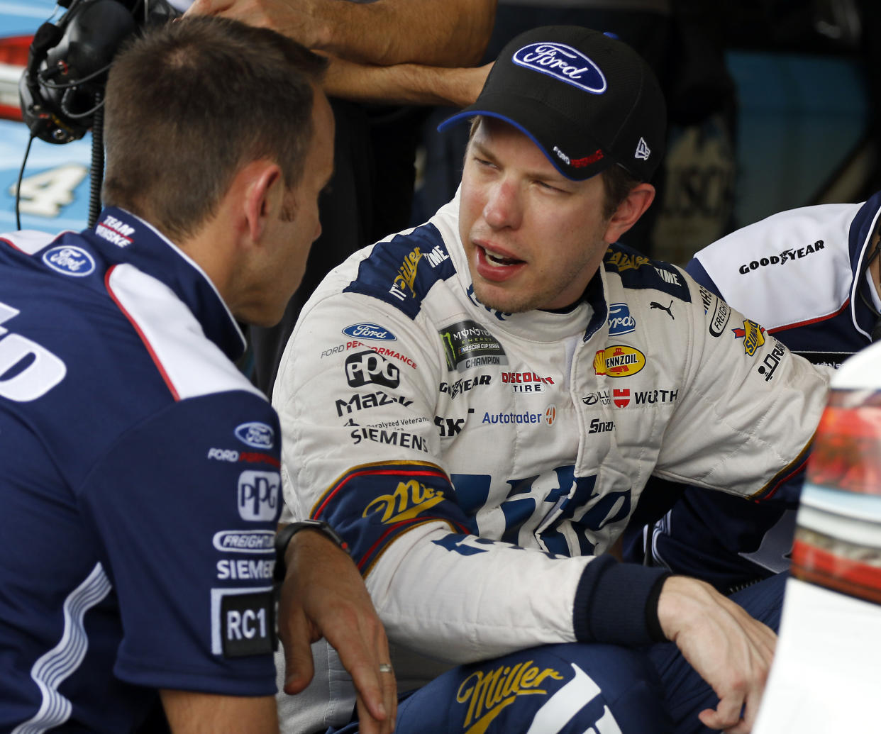 Brad Keselowski, right, talks with a crew member during a NASCAR auto racing practice session at Daytona International Speedway, Saturday, Feb. 10, 2018, in Daytona Beach, Fla. (AP Photo/Terry Renna)