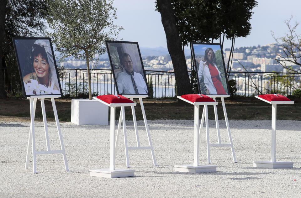 The portraits of, from the left, victims Nadine Devillers, Vincent Loques and Brazil's Simone Barreto Silva are pictured in Nice, southern France, Saturday Nov. 7, 2020, during a ceremony in homage to the three victims of an attack at Notre-Dame de Nice Basilica on October 29, 2020. Three people were killed in an Islamic extremist attack at Notre Dame Basilica in the city of Nice that pushed the country into high security alert. (Valery Hache; Pool via AP)