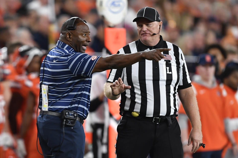 Syracuse coach Dino Babers, left, questions line judge Michael Kelley during the second half of the team's NCAA college football game against Boston College in Syracuse, N.Y., Friday, Nov. 3, 2023. (AP Photo/Adrian Kraus)