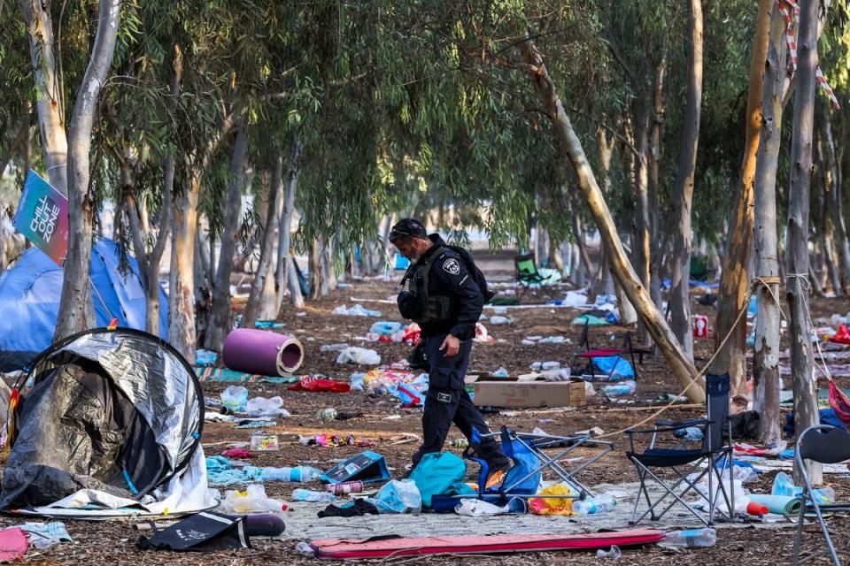 An Israeli officer walks on the ground of the Nova music festival in Re'im, Israel after the event was attacked by Hamas on 7 October (EPA)