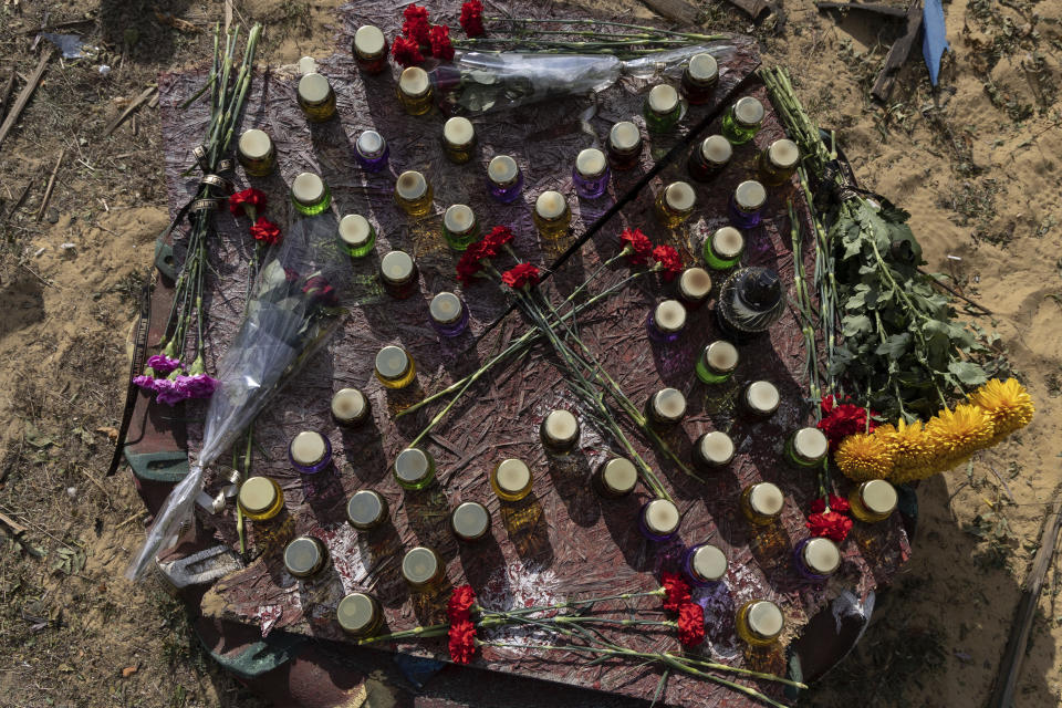 A memorial made with candles and flowers, which were brought by local residents in the village of Hroza near Kharkiv, Ukraine, Friday, Oct. 6, 2023. Ukrainian officials say at least 51 civilians were killed in a Russian rocket strike on a village store and cafe in the eastern part of the country in one of the deadliest attacks in recent months. (AP Photo/Alex Babenko)