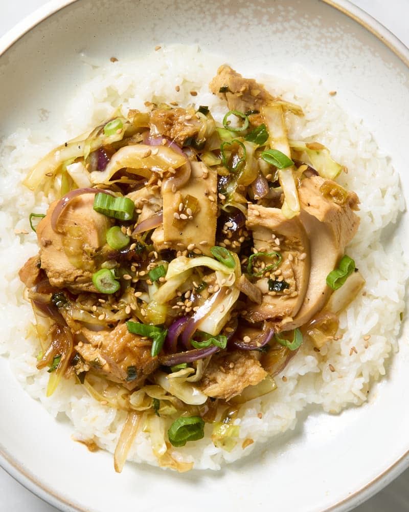 overhead shot of tuna stir fry served over rice in a white bowl.