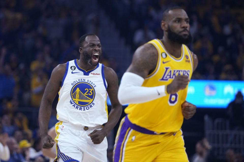 Warriors forward Draymond Green shouts and runs toward LeBron James after making a 3-point basket.