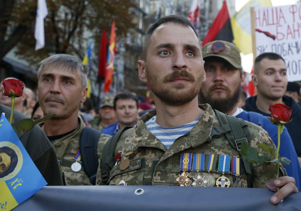 FILE In this file photo taken on Monday, Oct. 14, 2019, Ukrainian army veterans attend a rally marking Defense of the Homeland Day in center Kyiv, Ukraine. Ukraine's president sits down Monday, Dec. 9, 2019 for peace talks in Paris with Russian President Vladimir Putin in their first face-to-face meeting, and the stakes could not be higher. More than five years of fighting in eastern Ukraine between government troops and Moscow-backed separatists has killed more than 14,000 people, and a cease-fire has remained elusive. (AP Photo/Efrem Lukatsky, File)