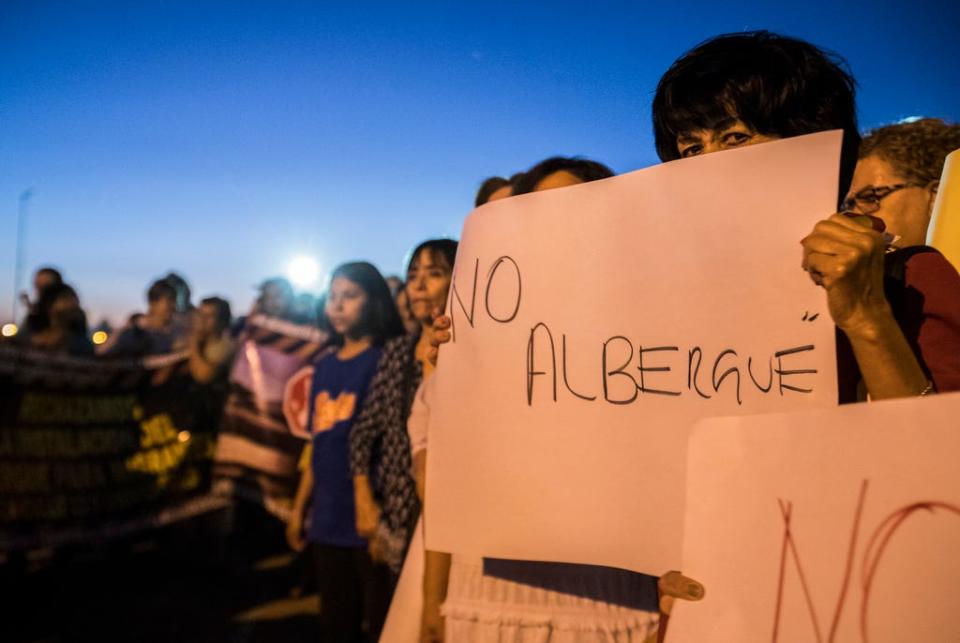 Residents of Mexicali, Mexico, gather Monday, Oct. 14, 2019, to protest the possible opening of a migrant shelter for migrants from Central America who are waiting for a court hearing in the U.S. in order to seek asylum. The residents are worried about the migrants devaluing their property, possible violence and the safety of school age children.