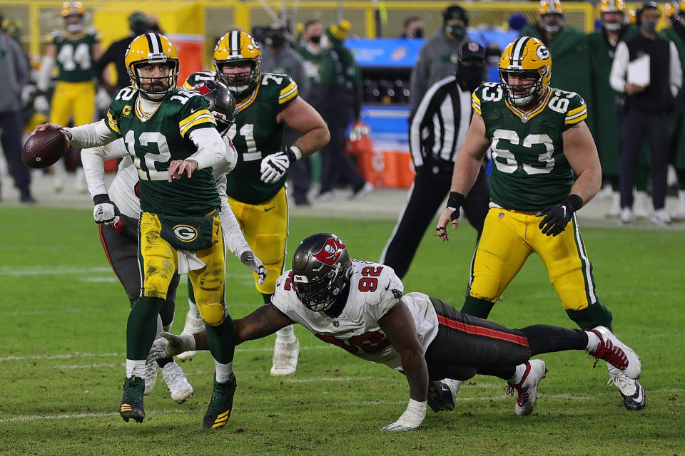 GREEN BAY, WISCONSIN - JANUARY 24: Aaron Rodgers #12 of the Green Bay Packers is pursued by William Gholston #92 of the Tampa Bay Buccaneers during the NFC Championship game at Lambeau Field on January 24, 2021 in Green Bay, Wisconsin. The Buccaneers defeated the Packers 31-26.  (Photo by Stacy Revere/Getty Images)