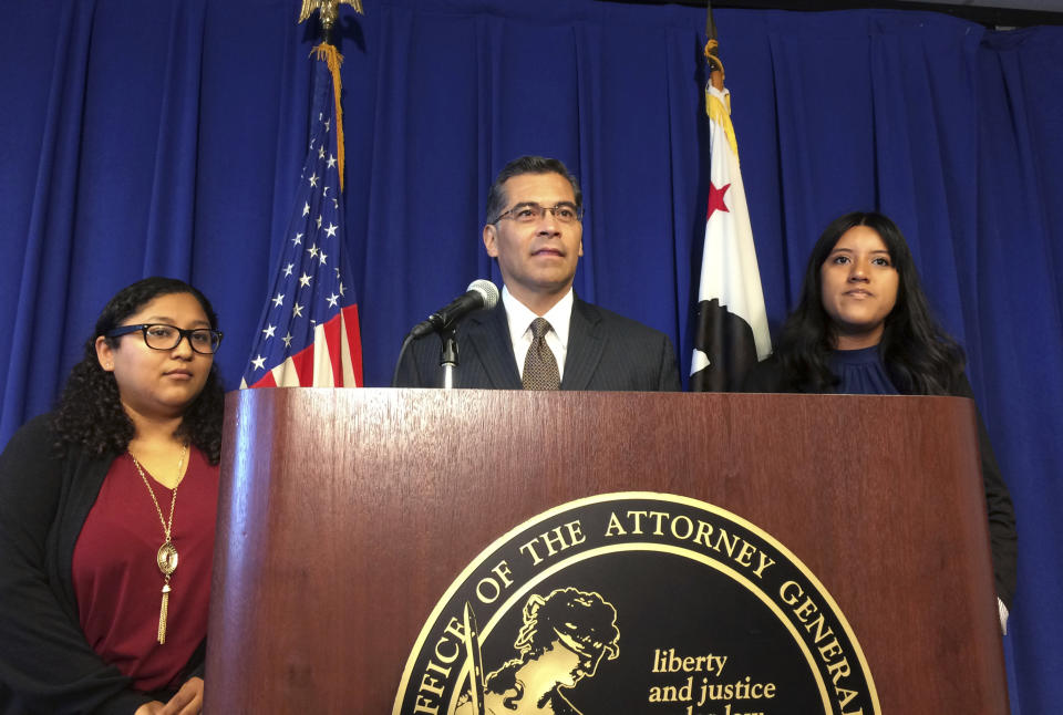 FILE - In this Monday, Sept. 11, 2017, file photo, California Attorney General Xavier Becerra is flanked by Rosa Barrientos, of East Los Angeles, left, and Eva Jimenez, of Visalia, right, as he announces a lawsuit challenging the Trump administration's decision to end a program that shields young immigrants from deportation, in Sacramento, Calif. Becerra and members of his staff in recent interviews discussed the DACA lawsuit as part of a broader glimpse into the office’s decision-making and structure to fight Trump administration policies. (AP Photo/Don Thompson, File)
