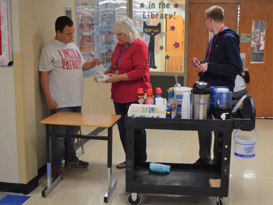 From left to right: Timothy James Storrs, a student in the RISE program at Lincoln High School; Cassia Oaks, an education assistant; Kaden Kittamus, a freshman at LHS, prepare for customers to come to the RISE coffee stand on May 20, 2022.