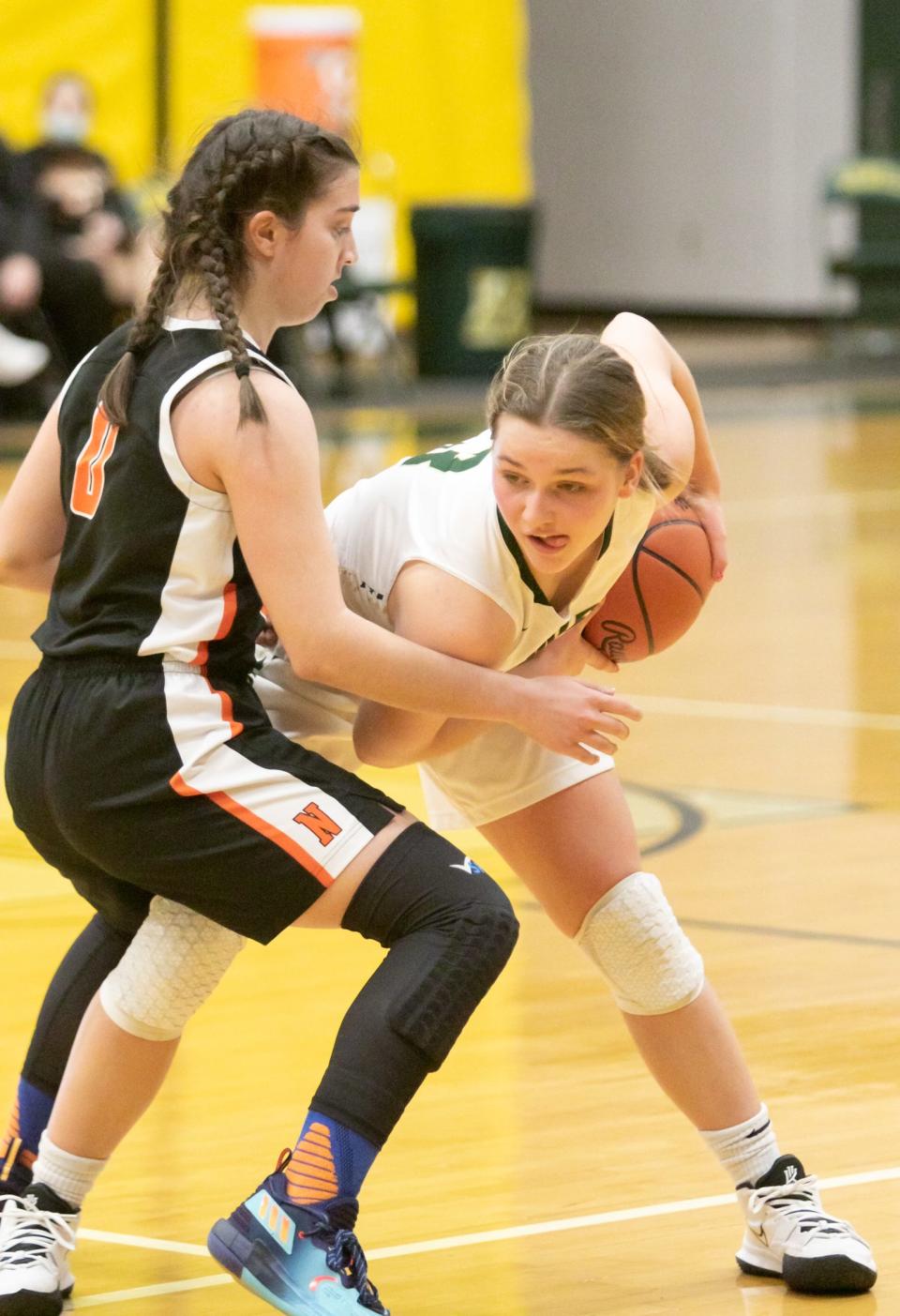 Howell's Sophie Daugard protects the basketball while defended by Northville's Eve Tanaskoska on Tuesday, Jan. 18, 2022.