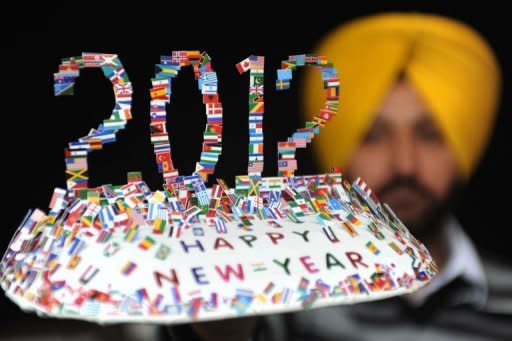 Indian artist Harwinder Singh Gill displays a creation made with 250 small flags of different countries reading "Happy New Year 2012" in Amritsar. Spectacular fireworks burst over Sydney Harbour to ring in the New Year at midnight, kicking off noisy celebrations for billions around the world to mark the end of 2011