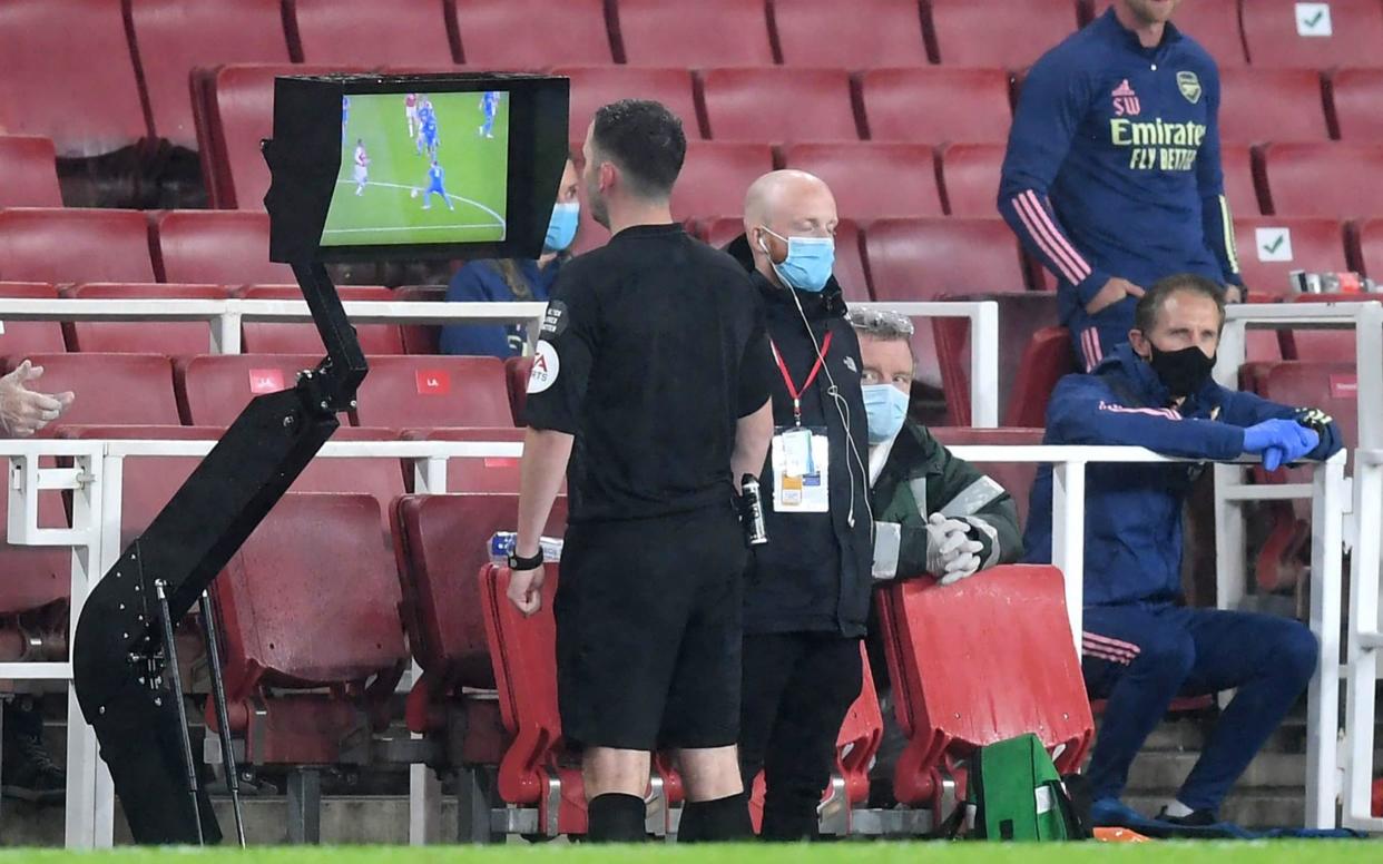 Chris Kavanagh checks a VAR decision on screen ahead of showing Eddie Nketiah of Arsenal a red card - GETTY IMAGES