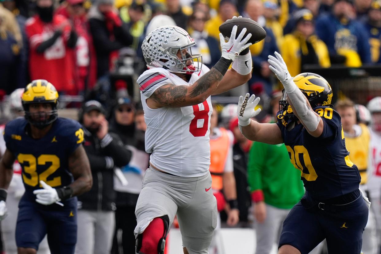 Nov 25, 2023; Ann Arbor, Michigan, USA; Ohio State Buckeyes tight end Cade Stover (8) catches a pass over Michigan Wolverines linebacker Jimmy Rolder (30) during the first half of the NCAA football game at Michigan Stadium.