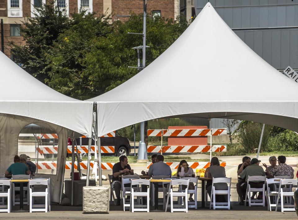 Lunchtime diners gather for outdoor dining Wednesday at The Blue Duck Barbecue Tavern in Peoria.