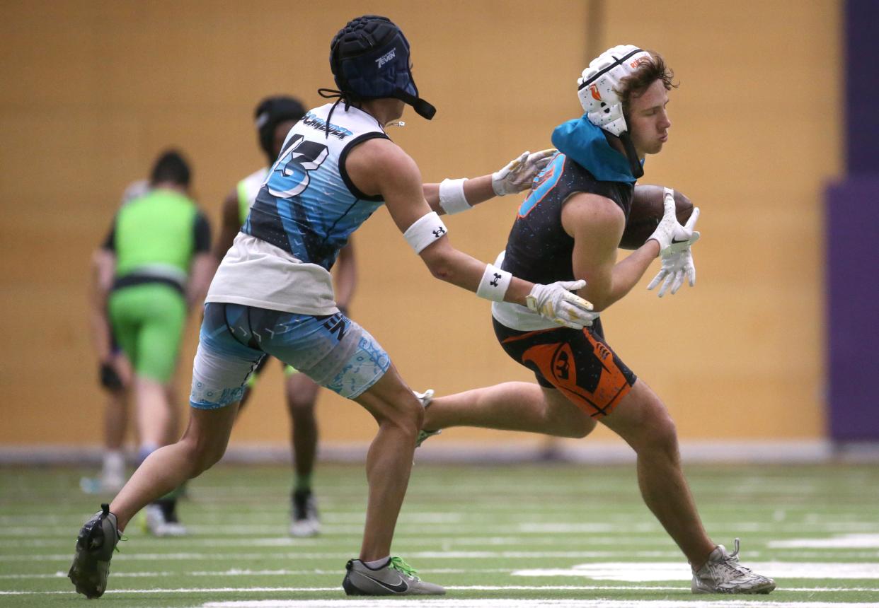 Dallas Miller, right, catches a pass during a 7-on-7 football tournament Saturday at the UNI Dome in Cedar Falls.