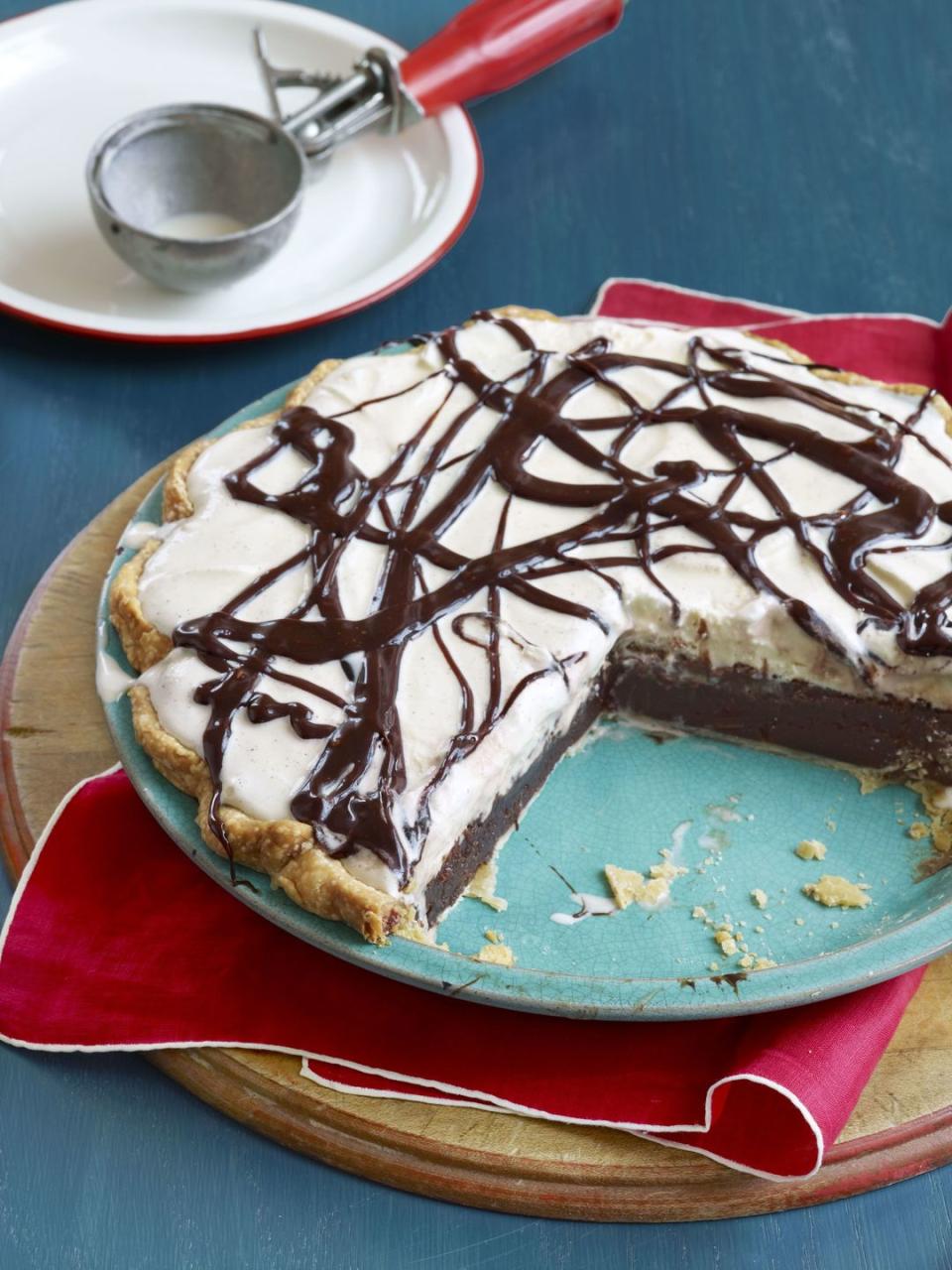 mississippi mud pie in a light teal colored pie dish with a large portion removed to show the inside