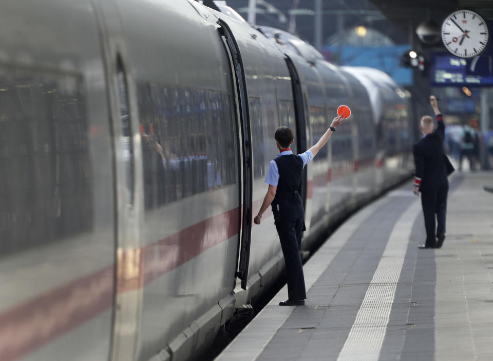 Conductors give the go for an ICE train the main train station in Frankfurt, Germany, Wednesday, June 19, 2019. (AP Photo/Michael Sohn)