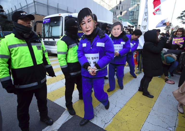 South Korean protesters wear prison uniforms and masks of President Park Geun-Hye (C) and other government officials during a demonstration in Seoul